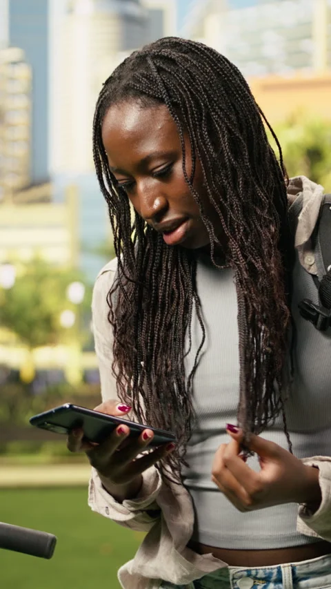 Vertical Video Courier fidgeting and checking food delivery app for new order Stock Footage 344379203