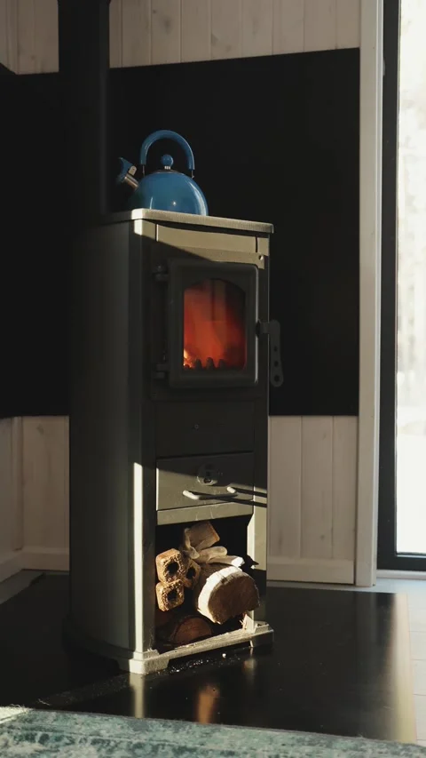 Vertical video. Cozy interior with a black wood stove with flames and a place to Stock Footage 311247284