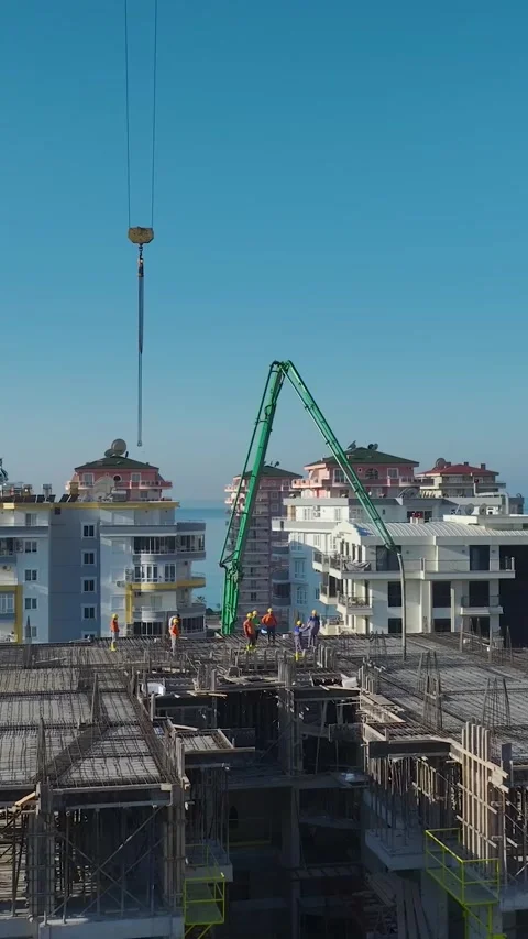 Vertical Video of a Crane Assisting With Wall Construction and Material Movement Stock Footage 342739685