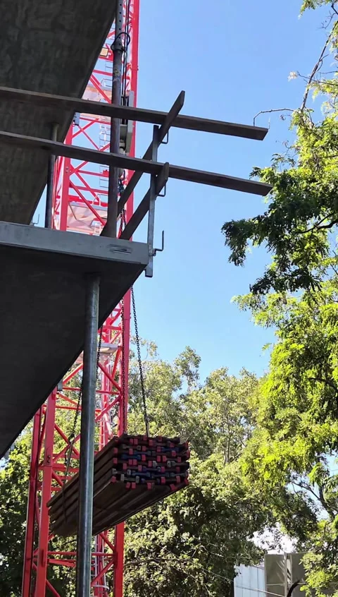 Vertical video of crane lowering timber joists on site Stock Footage 337484959