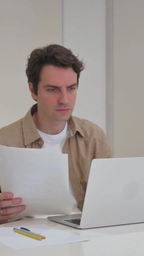 Vertical Video, Creative Man Celebrating while Working on Laptop and Documents Stock Footage 318045224