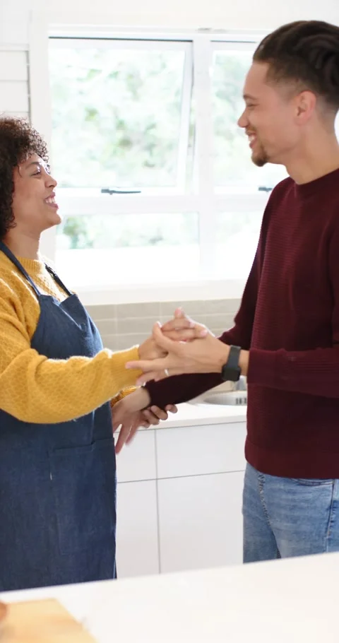 Vertical video: On cue couple dancing and twirling across kitchen countertop Stock Footage 345129216