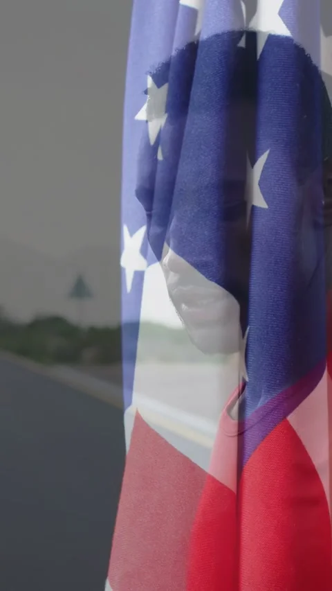 Vertical video: Cue man turning to camera flag shifting across face revealing Stock Footage 333862251