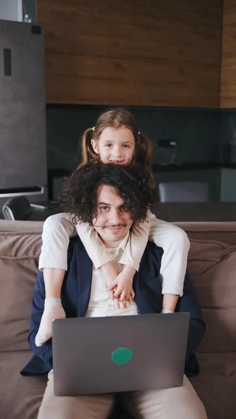Vertical video A curly-haired single dad working remotely from home on the couch Stock Footage 296840722