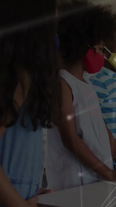 Vertical video: Curly student standing at table as node map drifting across Stock Footage 333174978
