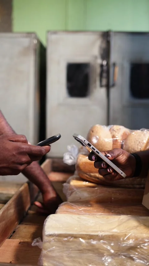 Vertical Video, Customer makes mobile money payment at bread bakery using phone Stock Footage 347146871