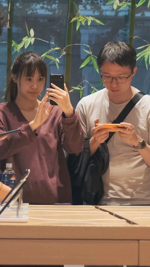 Vertical video: Customers crowds test new iPhone 17 in Apple store. Hands-on Stock Footage 322516236