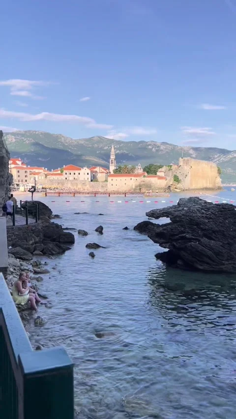 Vertical video of dancing ballerina statue on rocks with Budva old town Stock Footage 347276103