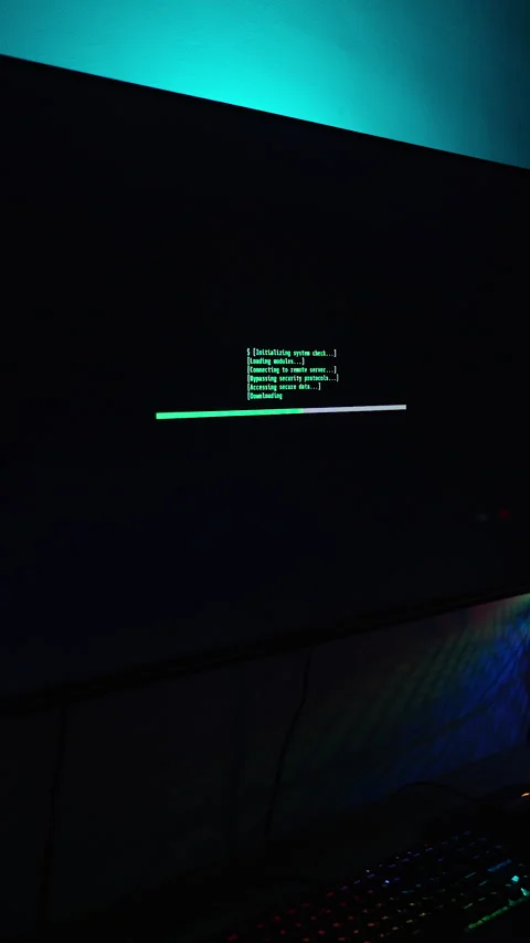 Vertical video. Dark Room with Computer Setup, Monitor Displaying Green Loading Stock Footage 281461230