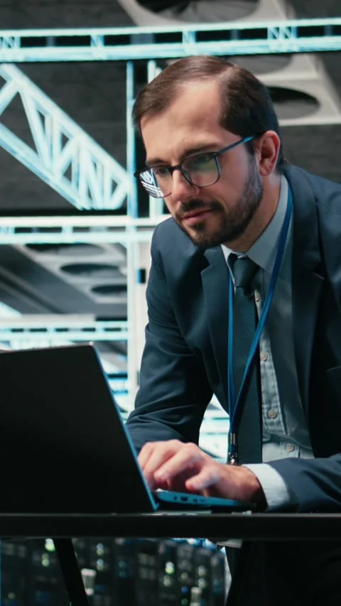Vertical video Data center admin typing on laptop keyboard, doing resource Stock Footage 329529912