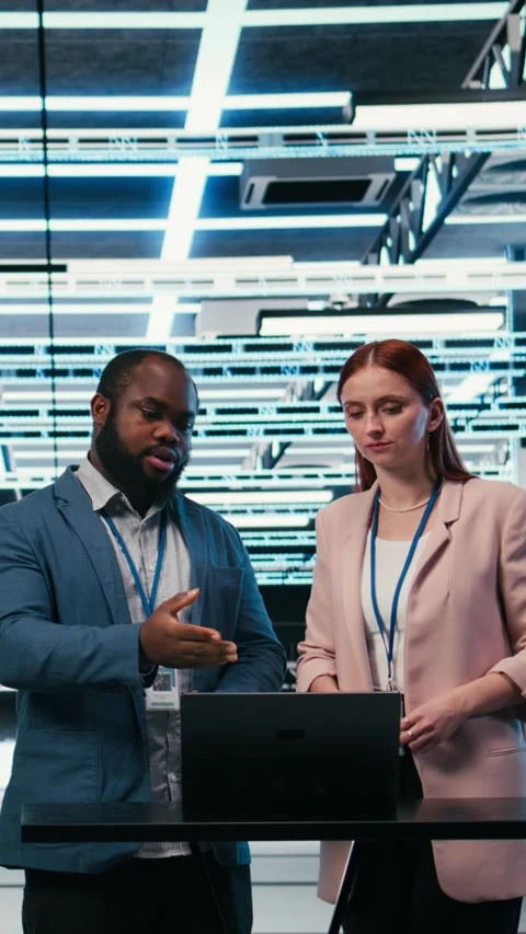 Vertical video Data center coworkers collaborating to manage cloud computing IT Stock Footage 330028442