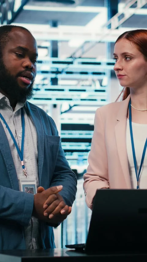 Vertical video Data center coworkers collaborating to manage cloud computing IT Stock Footage 330375981