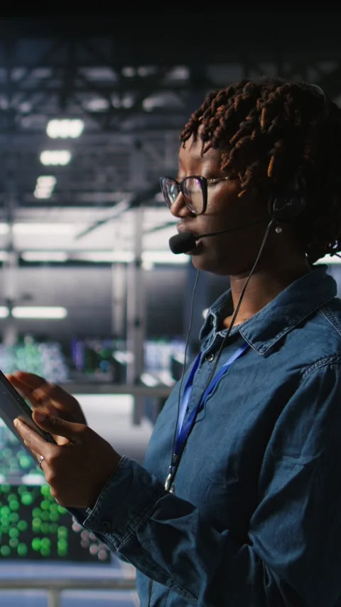 Vertical video Data center engineer wearing headset microphone providing remote Stock Footage 310774698