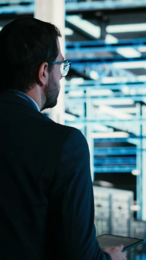 Vertical video Data center technician managing blue wireframe mesh gear Stock Footage 329529935