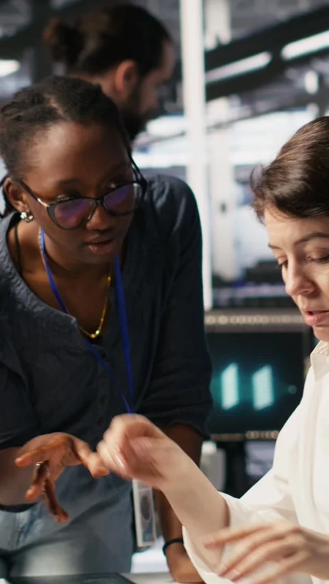 Vertical video Data center technicians adjusting blade server hardware powering Stock Footage 309247862