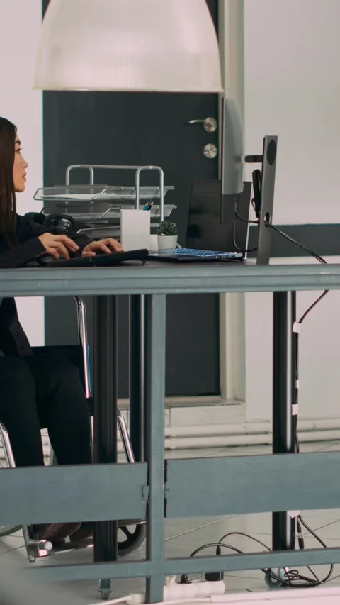 Vertical video: Database programer with physical disability writing code on Stock Footage 218575101