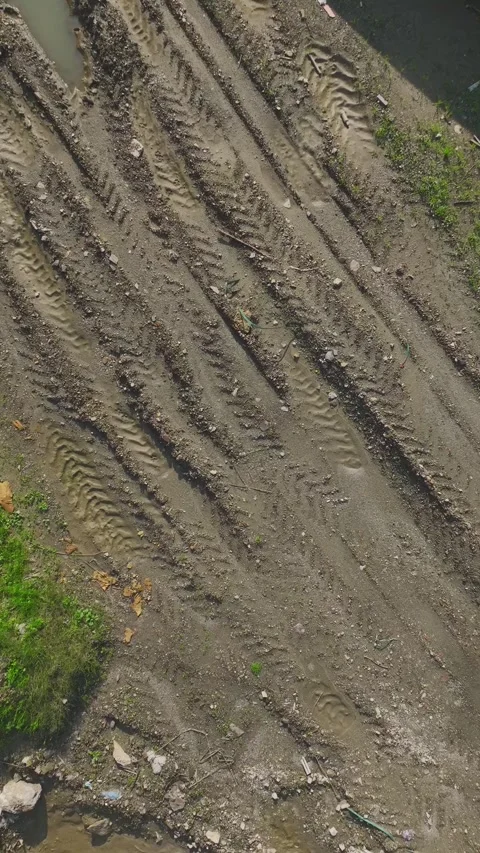 Vertical Video: Deep Tire Tracks Left by a Tractor on Soft Soil Captured Stock Footage 342915815