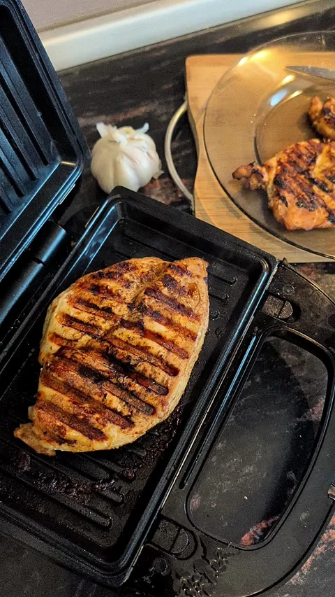 Vertical Video Of Delicious Chicken Breast Grilling On Electric Press Stock Footage 336746210