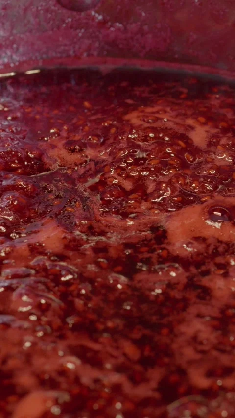 Vertical video Delicious homemade raspberry jam simmering in a stainless steel Stock Footage 323362425