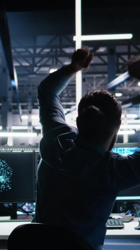 Vertical video Delighted developer celebrating in data center after successfully Stockbeeldmateriaal 313456489
