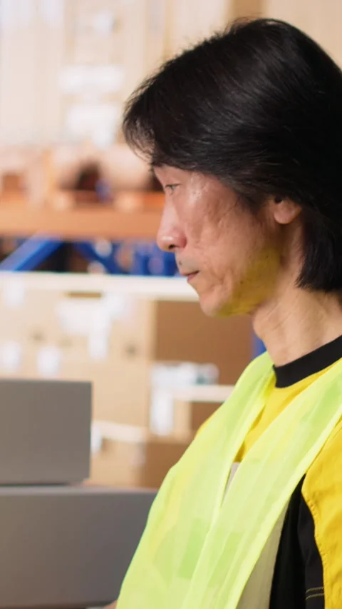 Vertical Video Depot asian worker processing online shopping orders on computer Stock Footage 312578963