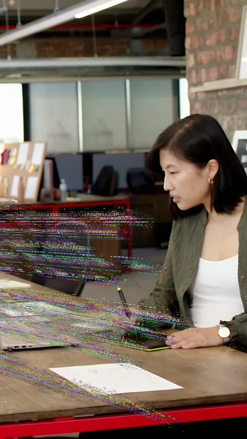 Vertical video: Designer editing, tapping pen on laptop, watching code overlay Stock Footage 333611089
