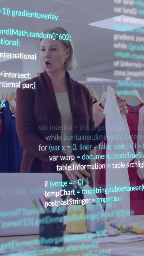 Vertical video: Designer holding white top, adjusting fit sparking blue code for Stock Footage 331047436