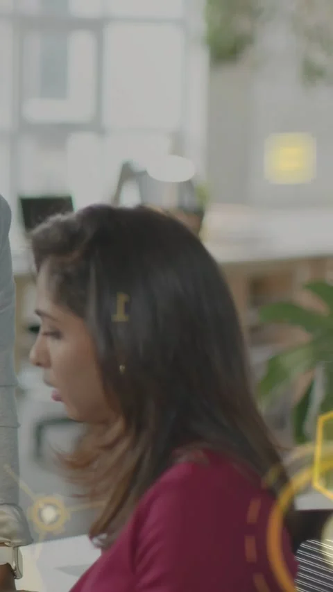 Vertical video: Desk worker turning to leaning coworker, hex HUDs sweeping and Stock Footage 335513669