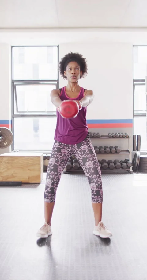 Vertical video of determined african american woman swinging kettlebell working Stock Footage 346723319