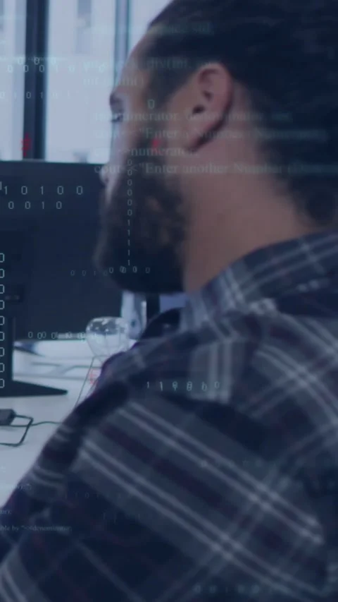 Vertical video: Dev sitting at desk watching monitor, code overlay starting and Stock Footage 334187646