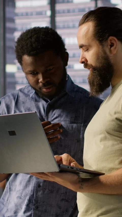 Vertical video Developer and colleague checking code on notebook, doing Stock Footage 319482188