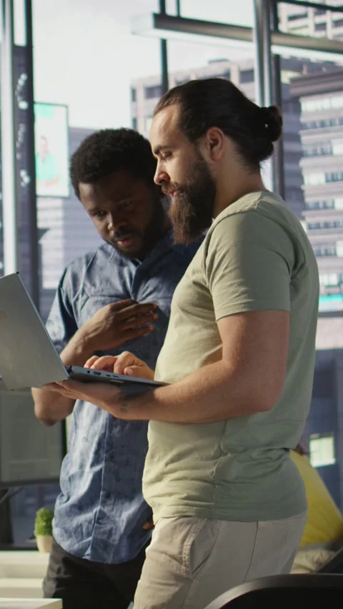 Vertical video Developer and colleague checking code on notebook, doing Stock Footage 319482227