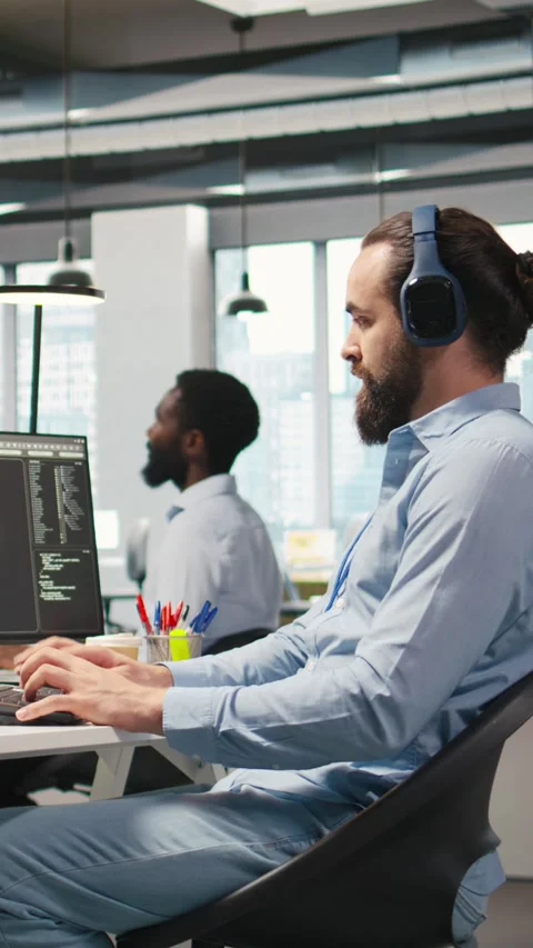 Vertical video Developer coding with AI language model assistance in office Stockbeeldmateriaal 312709326