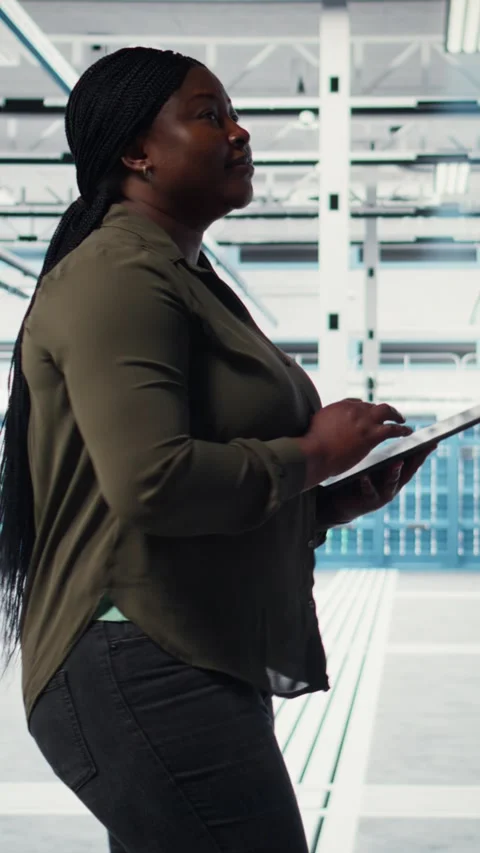 Vertical video Developer in data center using tablet to increase workload Stock Footage 317055412