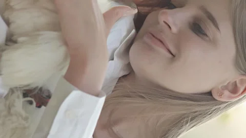 Vertical video. Devotion and joy: The Maltese lapdog and her mistress spend the Video stock 254112652