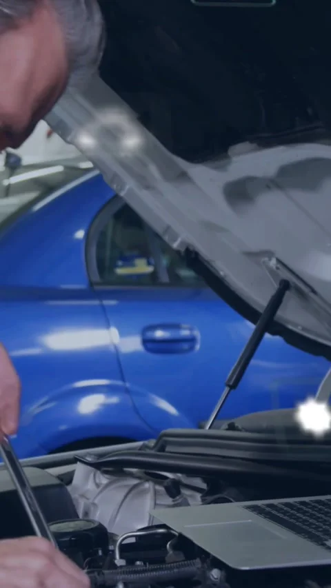 Vertical video: Diagnostic icons above laptop, mechanic leaning into engine Stock Footage 331822366