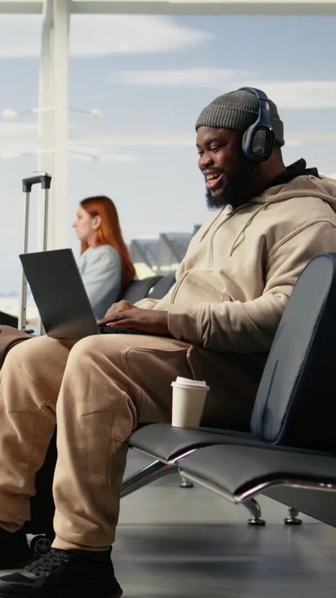 Vertical Video Digital nomad participating in online video call in airport Stock Footage 333611668