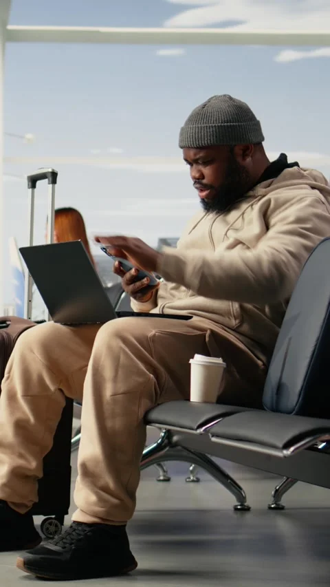 Vertical Video Digital nomad professional waiting for delayed flight in airport Video stock 333611667