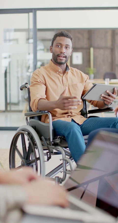 Vertical video of disabled african american in wheelchair with tablet talking in Stock-Footage 345319748