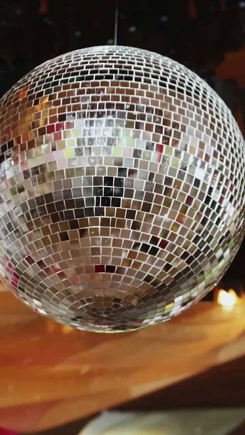 Vertical video. Disco ball. Hanging silver globe reflections create festive Stock Footage 324679066