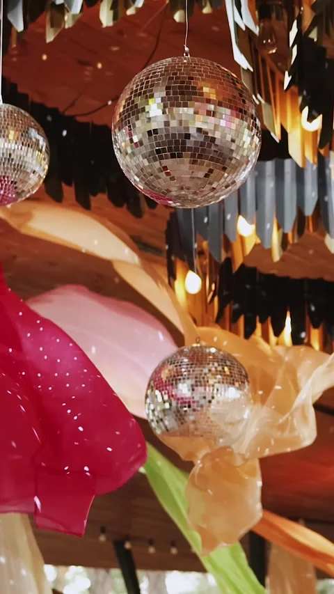 Vertical video. Disco balls hanging between colorful fabrics. Decor for a party Stock Footage 324678536
