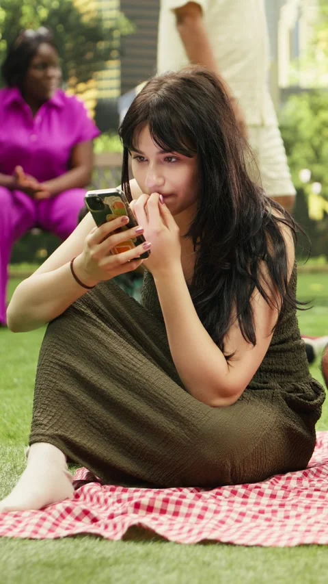 Vertical Video Disconnected couple scrolling through social media during picnic Stock Footage 341472539