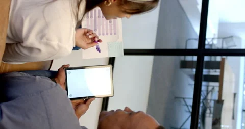 Vertical video: Discussing project, colleagues using tablet and holding document Video stock 299780995