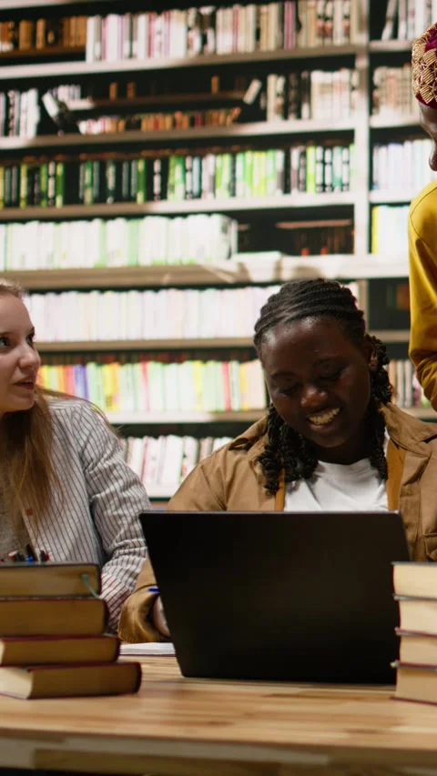 Vertical Video Diverse classmates in group study gather around laptop with study Stock Footage 337529602