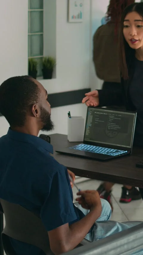 Vertical video: Diverse coders talking about source code on terminal window Stock Footage 218574745