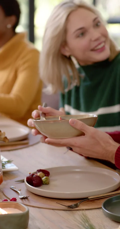 Vertical video: Diverse friends passing bowl, sharing meal after blonde scooping Видео 346735299