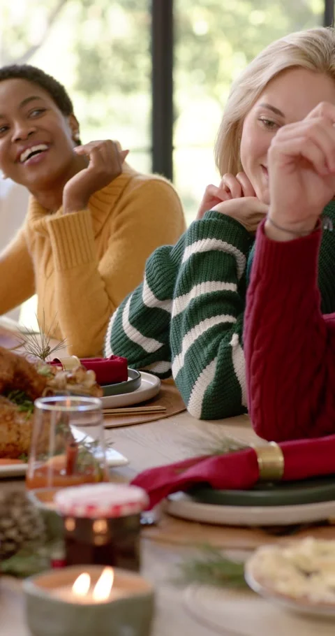 Vertical video: Diverse friends in sweaters laughing, pointing at turkey on Видео 346735292