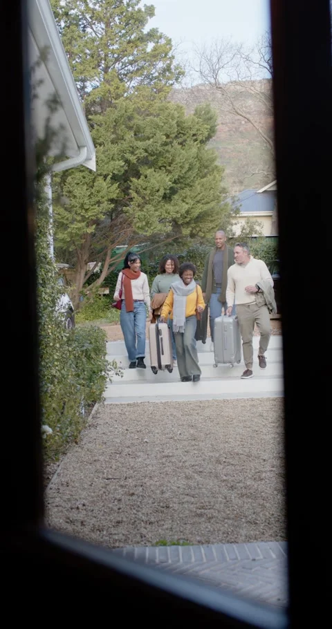 Vertical video: Diverse friends walking toward front door after travel, pulling Видео 346735362