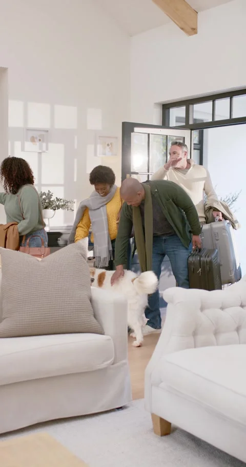 Vertical video: Diverse group arriving with rolling suitcase entering home Видео 346735367