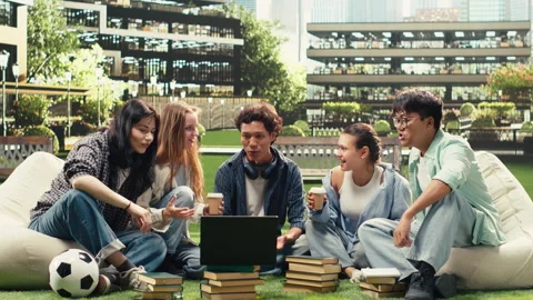 Vertical Video Diverse peers gathering on campus grass for group study session Stock Footage 340792818